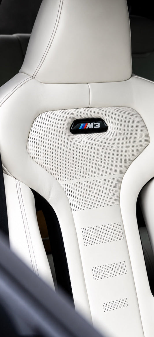 BMW M3 white leather seat perforation and illuminated-style M3 badge detail